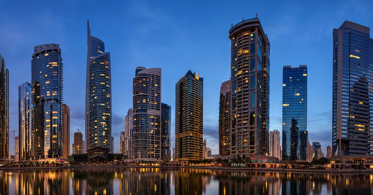 JLT towers around a lake at dusk — tax consultant for Jumeirah Lake Towers companies